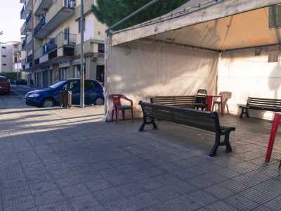 Su un marciapiede scorgiamo un gazebo con sedie e tavolini, punto di ritrovo per uomini e anziani del quartiere che spesso sfruttano lo spazio per giocare a carte